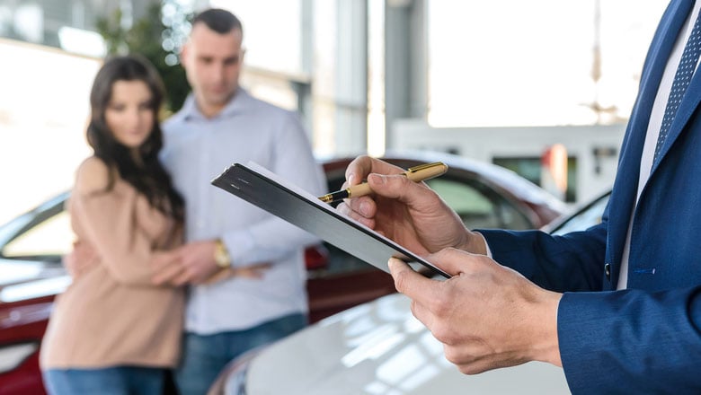 Couple in a car dealership looking at a car