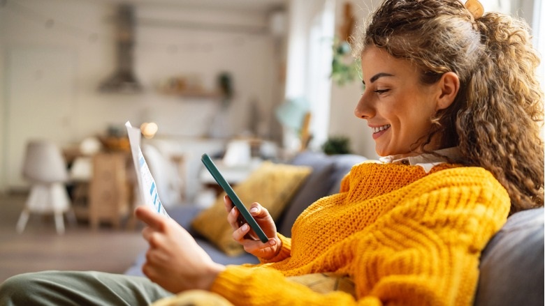 Young woman using e-banking to pay bills from home