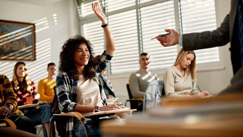 Girl with hand raised in class