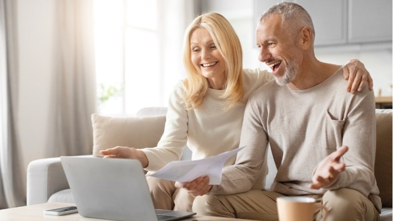 Happy couple with papers and laptop