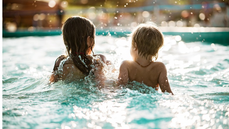 little boy and girl splashing in pool