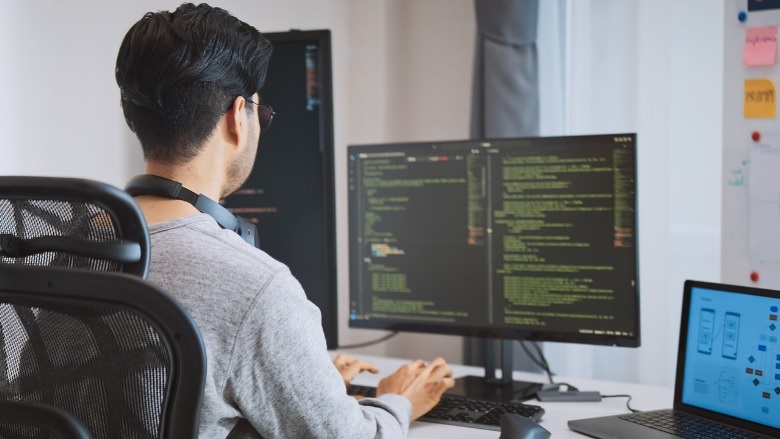 man looking at multiple computer screens