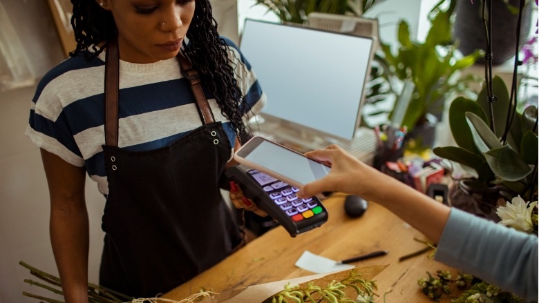 business woman holding card reader for customer