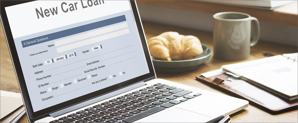 Laptop with a New Car Loan Application on screen