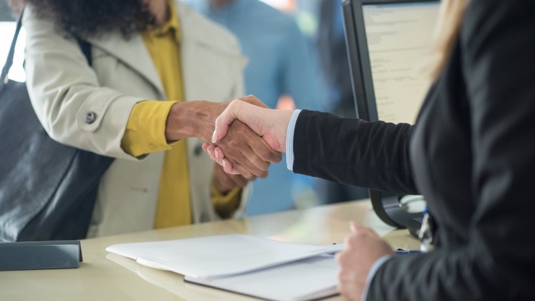 Customer shaking hands with bank teller at bank